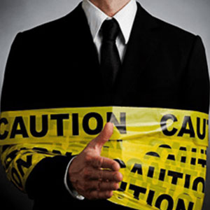 A professional man in formal attire holding caution tape- Moss Bollinger LLP