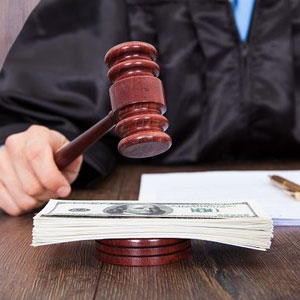 A judge's gavel and money on a wooden table- Moss Bollinger LLP