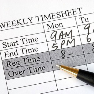 A weekly timesheet with a pen, used for tracking work hours- Moss Bollinger LLP