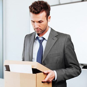 A professional man in a suit holding a box- Moss Bollinger LLP