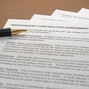 Contractor agreement on table: A legal document outlining terms between a contractor and employer- Moss Bollinger LLP