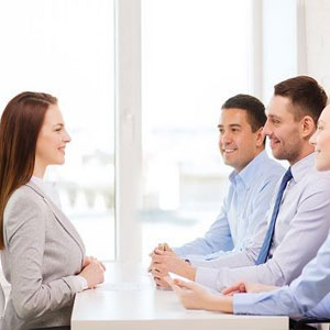 A group of business professionals discussing at a conference table, engaged in a meeting- Moss Bollinger LLP