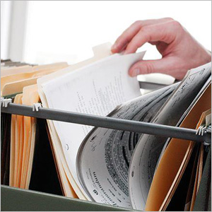 A person inspecting personnel files in a file drawer- Moss Bollinger LLP