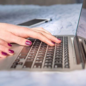 A woman's hands typing on a laptop computer- Moss Bollinger LLP