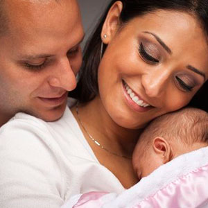 A couple cradling their newborn baby, radiating love and joy- Moss Bollinger LLP