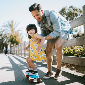 A man and a little girl happily riding a skateboard together, enjoying a fun and adventurous moment- Moss Bollinger LLP