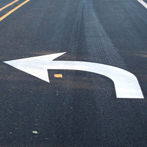 Image of a white arrow pointing right on a road - Moss Bollinger LLP