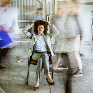 An office setting featuring a woman on a chair, with unfocused people - Moss Bollinger LLP