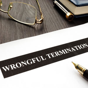 Wrongful termination document on a table. a pen & glasses lie next to the document - Moss Bollinger LLP