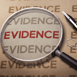 Evidence on paper with magnifying glass and pen, - Moss Bollinger LLP