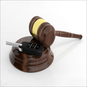 Wooden gavel and car key on white background - Moss Bollinger LLP
