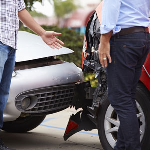 Two men standing beside a damaged car - Moss Bollinger LLP