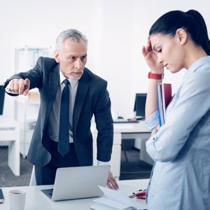 A man and woman in an office discussing about the wrongful termination. - Moss Bollinger LLP